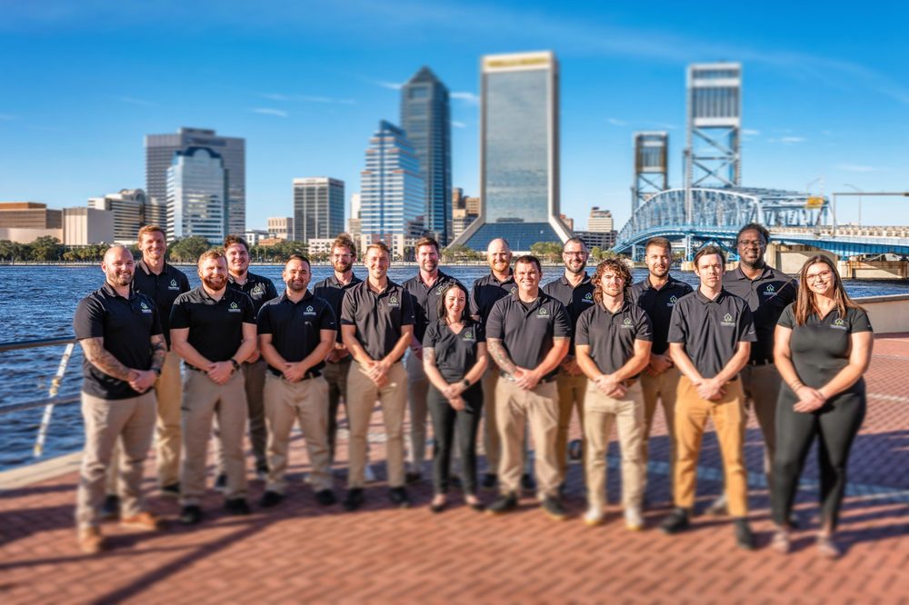 HouseScan Inspections team standing along the Jacksonville riverfront with the downtown skyline behind them
