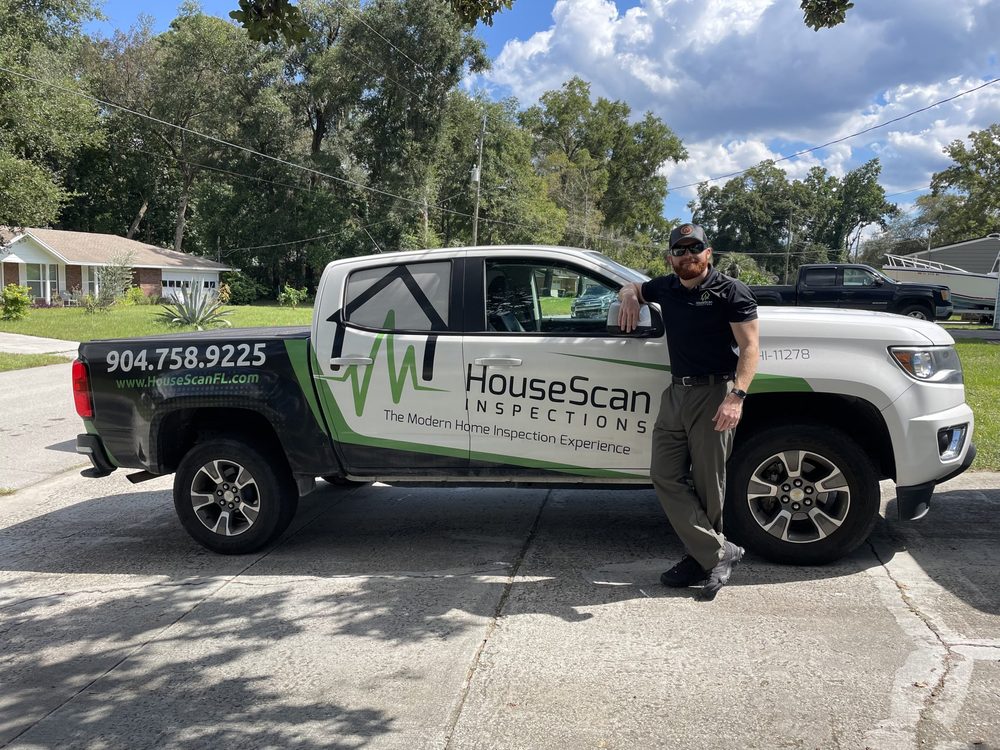 HouseScan inspector standing beside a branded HouseScan truck on a residential street