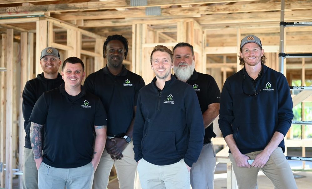 HouseScan team standing inside a new construction home during framing