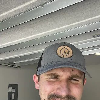 HouseScan inspector squinting into the camera for a close-up selfie in a garage