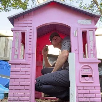 HouseScan inspector squeezed inside a child's pink playhouse during an inspection